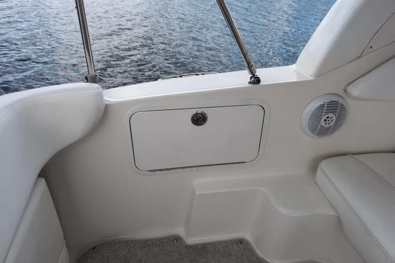 Slide: The Image of Interior view of a 2005 Sea Ray Sundancer 280 boat, featuring white seating and storage. - 19