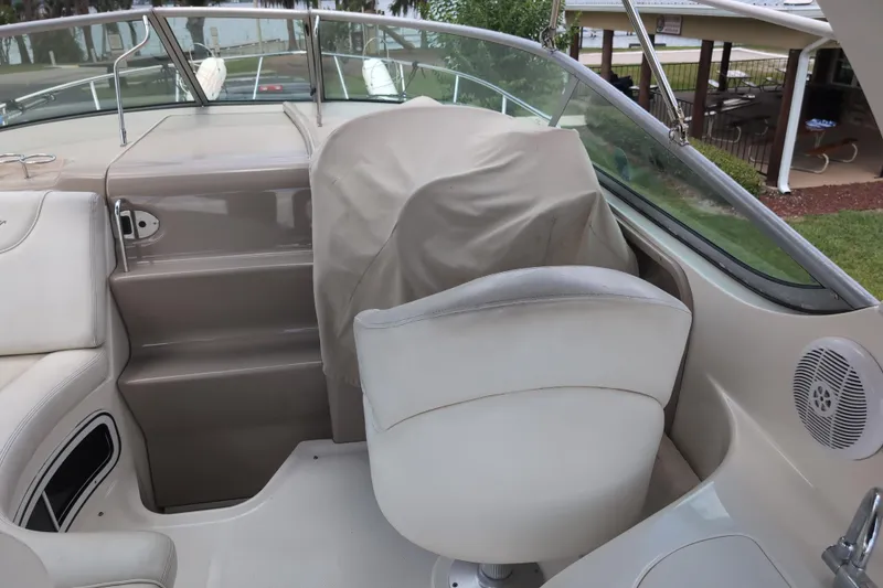 Slide: The Image of 2005 Sea Ray Sundancer 280 cockpit with covered helm seat and steering wheel. - 25
