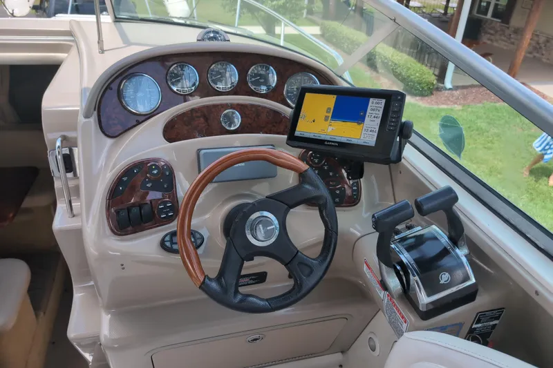 Slide: The Image of 2005 Sea Ray Sundancer 280 helm with GPS, gauges, and wood-accented steering wheel. - 27