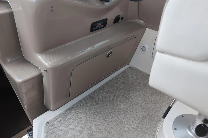 Slide: The Image of Interior view of a 2005 Sea Ray Sundancer 280 boat, featuring beige paneling and carpeted flooring. - 33