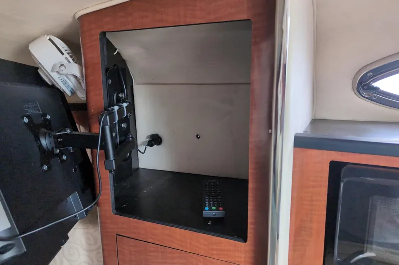 Slide: The Image of 2005 Sea Ray Sundancer 280 interior with TV mount and remote control. - 38