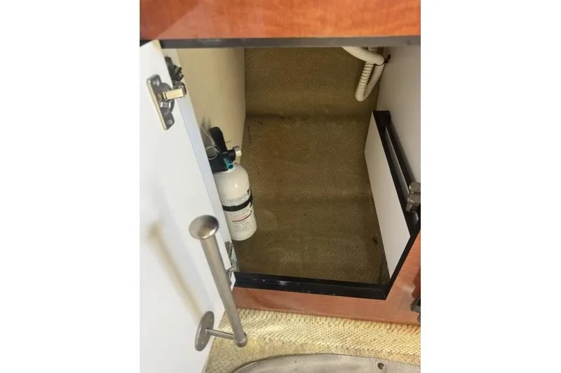 Slide: The Image of Open cabinet on 2005 Sea Ray Sundancer 280 boat, showing interior storage space. - 40
