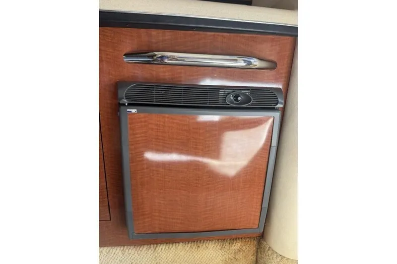 Slide: The Image of 2005 Sea Ray Sundancer 280 interior with a compact wooden cabinet and built-in refrigerator. - 41
