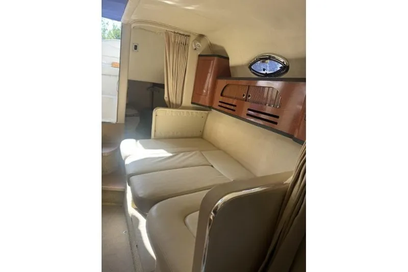 Slide: The Image of Interior of 2005 Sea Ray Sundancer 280, featuring beige seating and wooden cabinetry. - 48