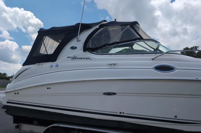 Slide: The Image of 2005 Sea Ray Sundancer 280 boat with black canopy under a partly cloudy sky. - 5