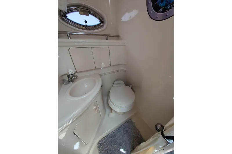 Slide: The Image of 2005 Sea Ray Sundancer 280 bathroom with sink, toilet, and porthole window. - 62