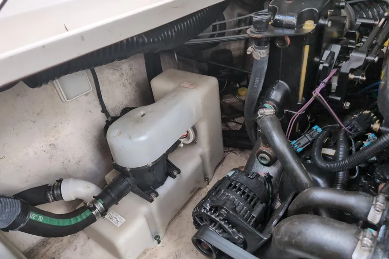 Slide: The Image of Engine compartment of a 2005 Sea Ray Sundancer 280, showcasing mechanical components and hoses. - 71