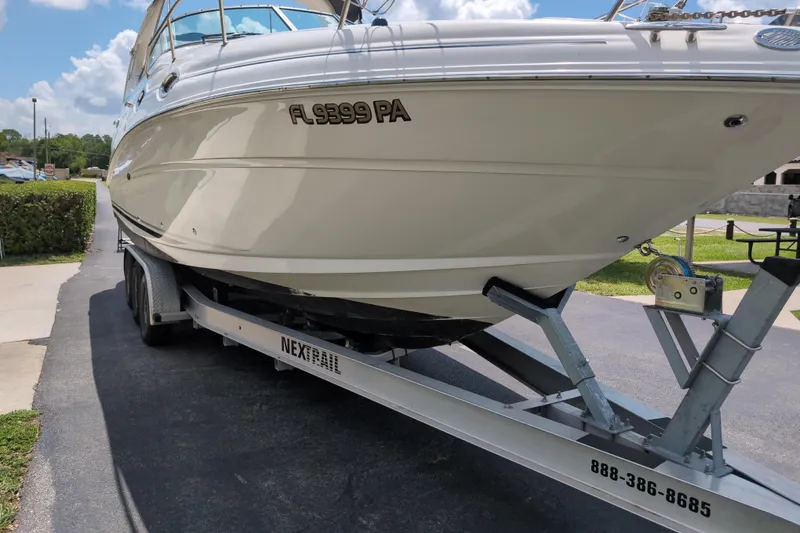 Slide: The Image of 2005 Sea Ray Sundancer 280 on trailer, parked outdoors under a clear sky. - 81