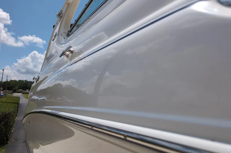 Slide: The Image of 2005 Sea Ray Sundancer 280 boat side view under clear blue sky. - 85