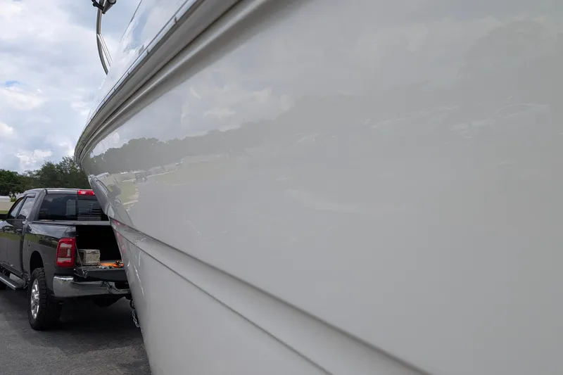 Slide: The Image of 2005 Sea Ray Sundancer 280 boat beside a parked truck under a cloudy sky. - 87
