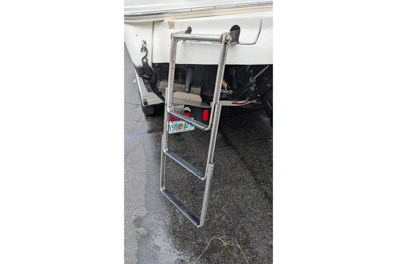Slide: The Image of 2005 Sea Ray Sundancer 280 with extended swim ladder on wet pavement. - 9