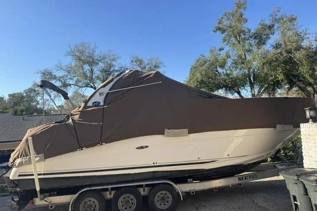 Slide: The Image of 2005 Sea Ray Sundancer 280 boat covered on trailer, surrounded by trees. - 95