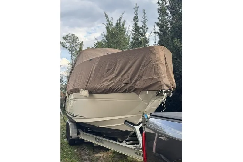 Slide: The Image of Covered 2005 Sea Ray Sundancer 280 boat on trailer, surrounded by trees. - 96