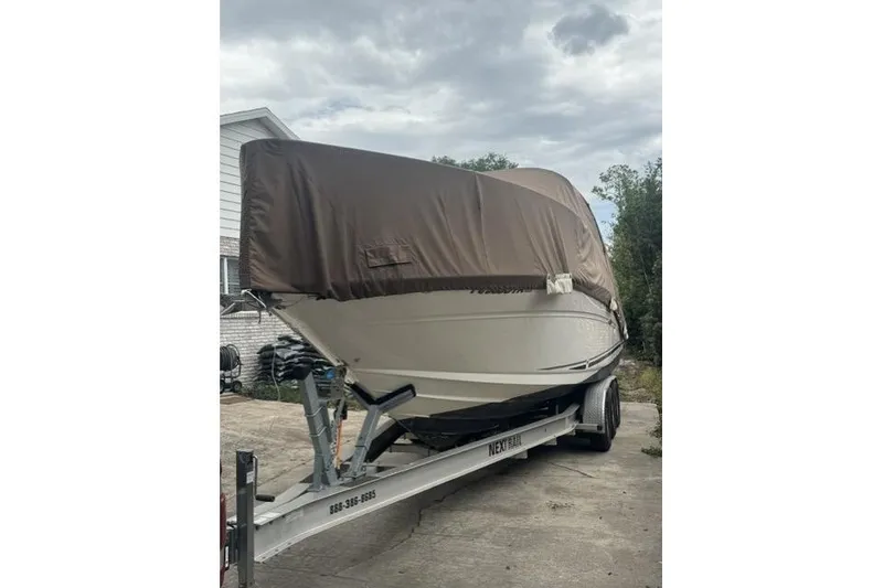 Slide: The Image of 2005 Sea Ray Sundancer 280 boat covered on trailer, parked outdoors. - 97