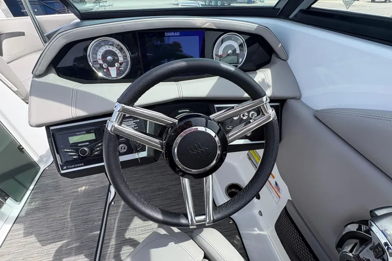 Slide: The Image of 2023 Four Winns HD3 boat dashboard with steering wheel and control panel. - 15