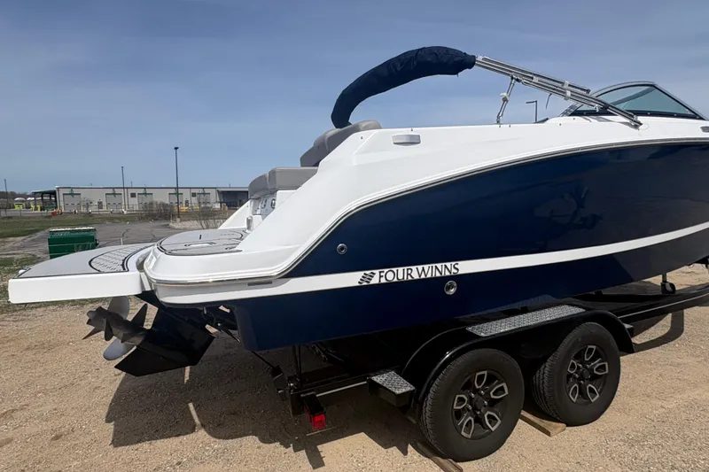 Slide: The Image of 2023 Four Winns HD3 boat on trailer, featuring sleek design and modern amenities. - 2