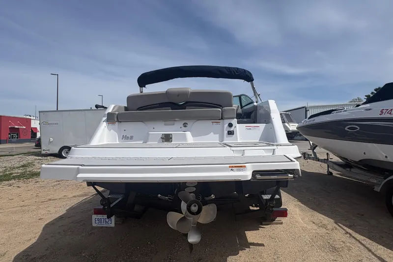 Slide: The Image of 2023 Four Winns HD3 boat rear view with propeller, parked on sandy ground. - 4