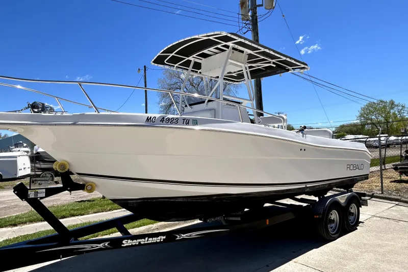 The Image of 2004 Robalo R230 Center Console boat on trailer under clear blue sky. - 0