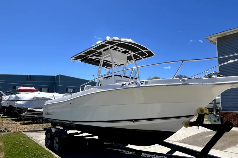 Slide: The Image of 2004 Robalo R230 Center Console boat on trailer under clear blue sky. - 1