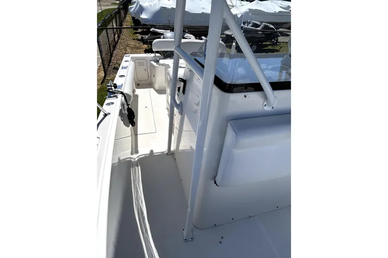 Slide: The Image of 2004 Robalo R230 Center Console boat deck, featuring clean white surfaces and sturdy railings. - 11