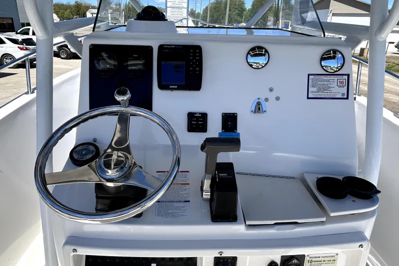 Slide: The Image of 2004 Robalo R230 Center Console boat dashboard with steering wheel and controls. - 13