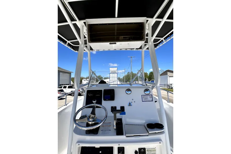 Slide: The Image of 2004 Robalo R230 Center Console boat dashboard with steering wheel and gauges. - 14