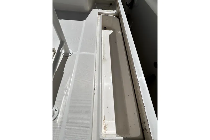 Slide: The Image of 2004 Robalo R230 Center Console boat deck with storage compartment. - 18