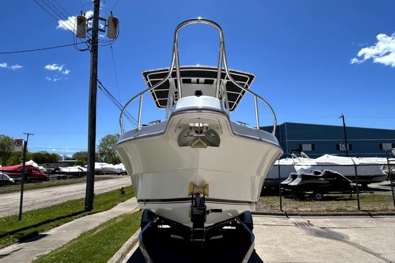 Slide: The Image of 2004 Robalo R230 Center Console boat on trailer under clear blue sky. - 2