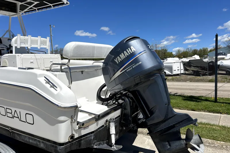 Slide: The Image of 2004 Robalo R230 Center Console boat with Yamaha four-stroke engine, parked outdoors. - 4