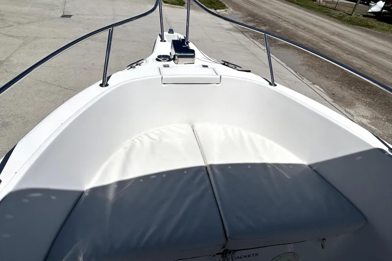 Slide: The Image of 2004 Robalo R230 Center Console boat bow with cushioned seating and railings. - 7