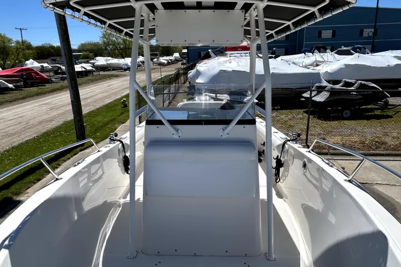 Slide: The Image of 2004 Robalo R230 Center Console boat with T-top, docked in a marina under clear skies. - 8