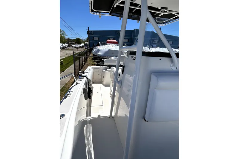 Slide: The Image of 2004 Robalo R230 Center Console boat, side view, docked outdoors under clear blue sky. - 9