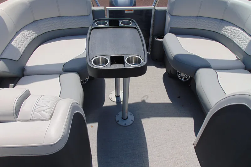 Slide: The Image of Luxurious seating area on a 2020 Godfrey Monaco 235 SB pontoon boat with a central table. - 12