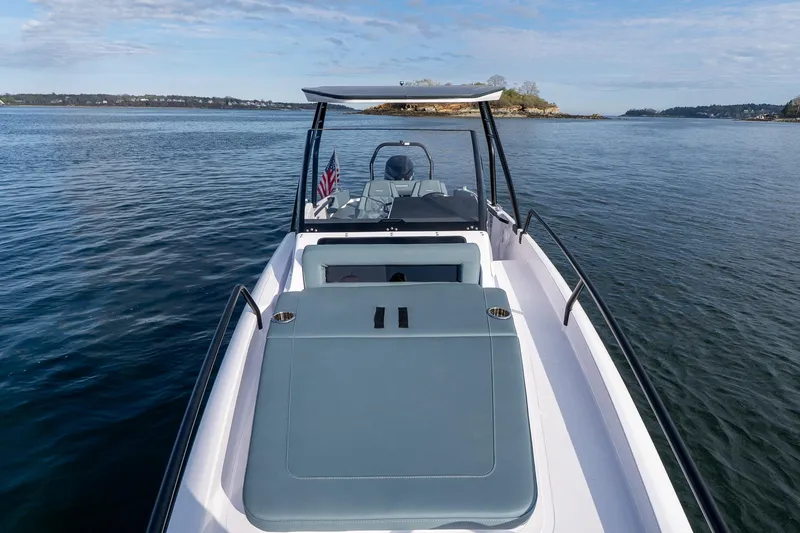 Slide: The Image of 2025 Axopar Cross Top boat on calm water, showcasing sleek design and spacious deck. - 12