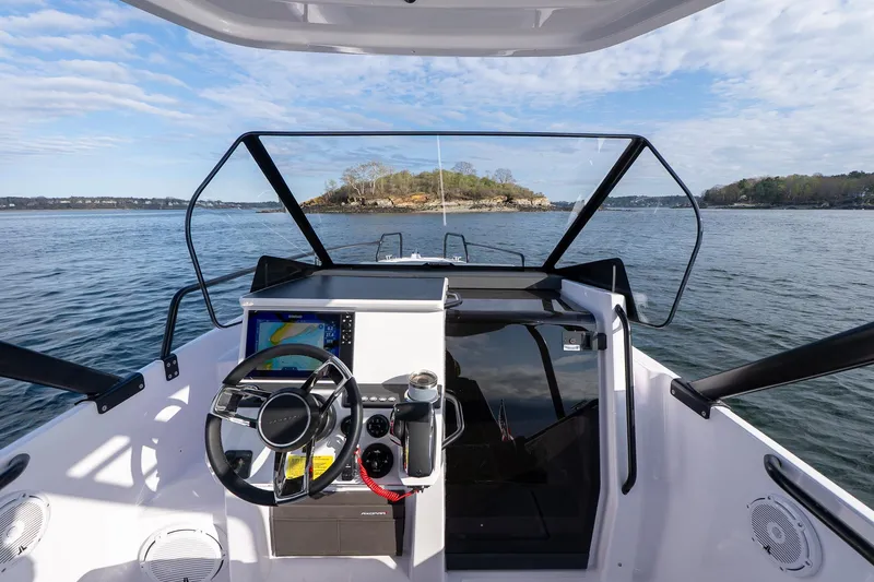 Slide: The Image of 2025 Axopar Cross Top boat dashboard with scenic ocean view. - 16