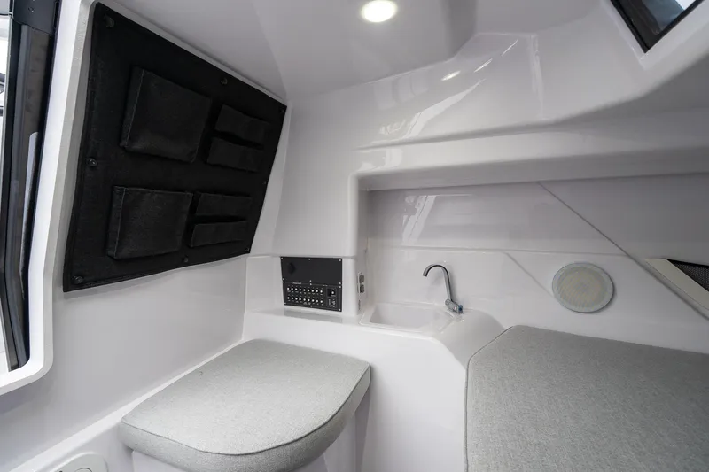 Slide: The Image of 2025 Axopar Cross Top interior with modern seating and compact sink. - 21