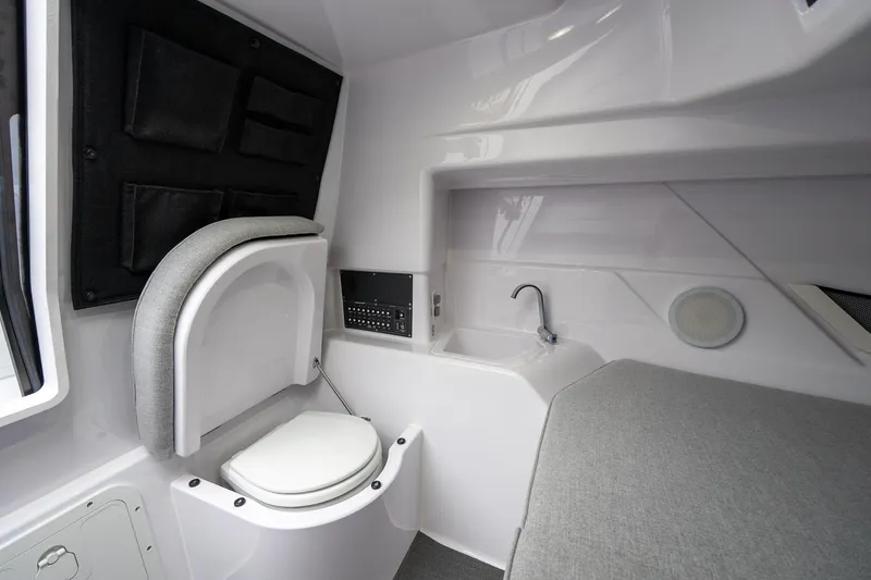 Slide: The Image of 2025 Axopar Cross Top interior with compact toilet and sink setup. - 22