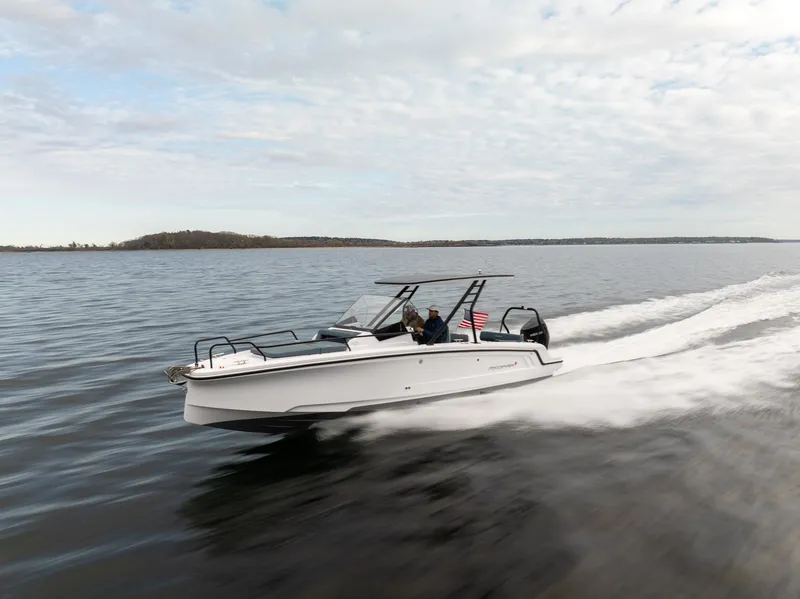 Slide: The Image of 2025 Axopar Cross Top boat cruising on open water under a cloudy sky. - 4