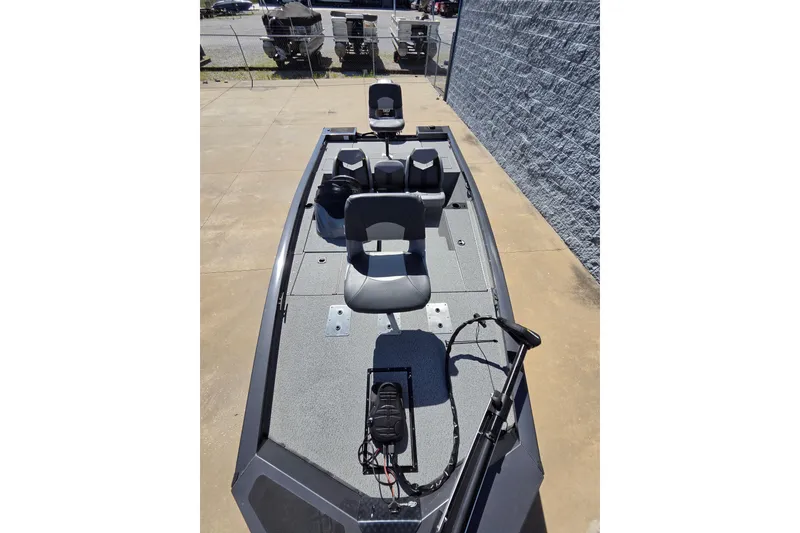 Slide: The Image of 2022 G3 Sportsman 1710 fishing boat with seating and trolling motor, parked outdoors. - 16