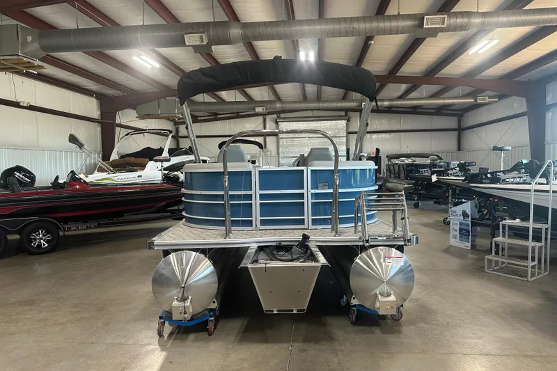 Slide: The Image of 2025 Trifecta 20RFLE2.75 pontoon boat displayed in a spacious indoor showroom. - 3