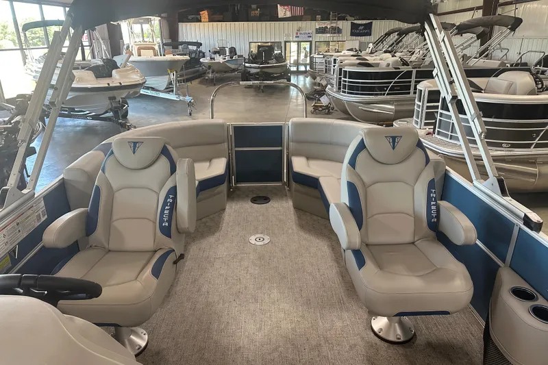 Slide: The Image of Interior view of 2025 Trifecta 20RFLE2.75 pontoon boat with luxurious seating in showroom. - 5