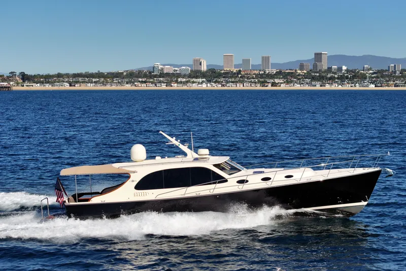 Slide: The Image of 2015 Palm Beach Motor Yachts PB45 cruising on blue ocean with city skyline backdrop. - 1