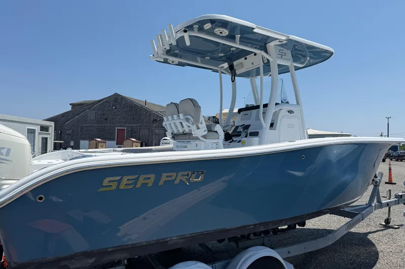 Slide: The Image of 2019 Sea Pro 239 Center Console boat on trailer, blue hull, outdoor setting. - 2