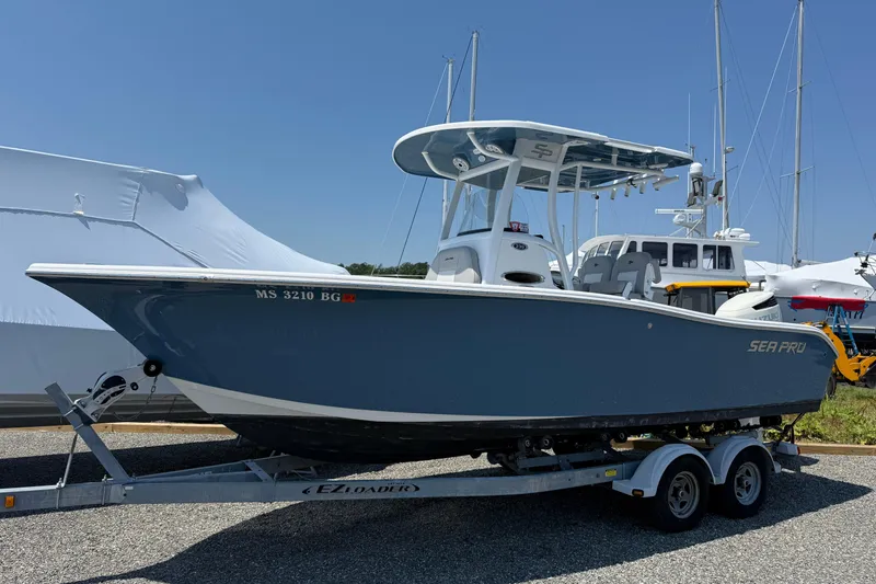 Slide: The Image of 2019 Sea Pro 239 Center Console boat on trailer, parked outdoors under clear sky. - 1