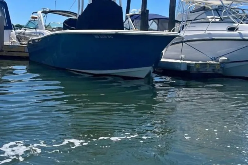 Slide: The Image of 2019 Sea Pro 239 Center Console boat docked at marina, surrounded by water and other boats. - 7