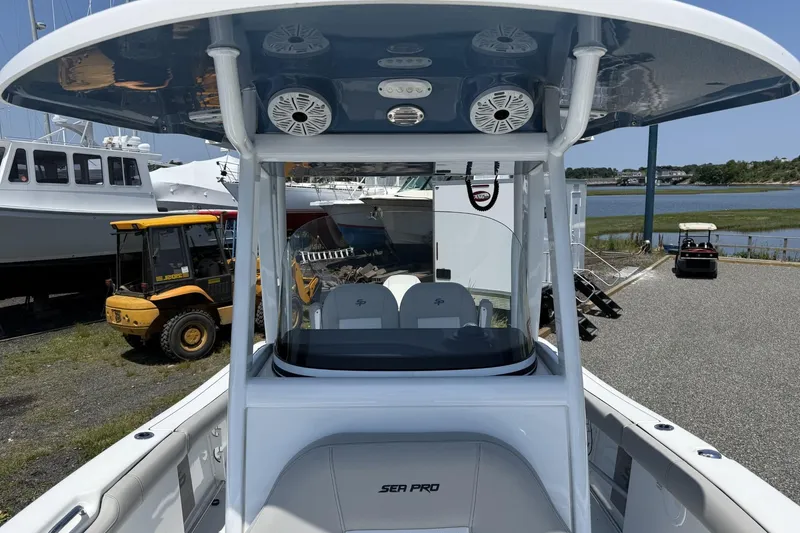 Slide: The Image of 2019 Sea Pro 239 Center Console boat with T-top and speakers, docked near water. - 12