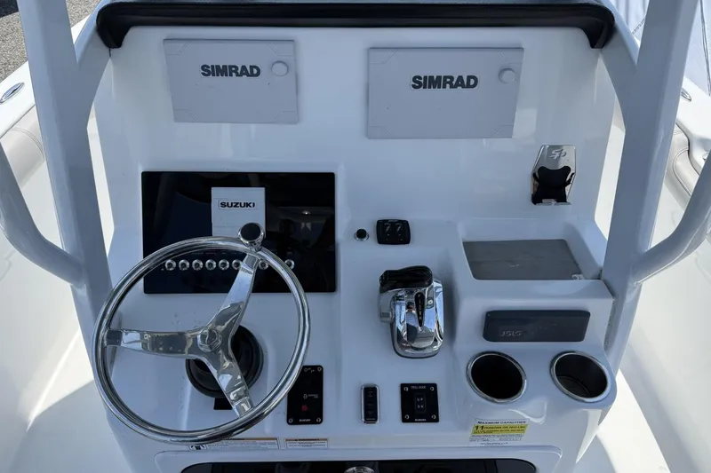 Slide: The Image of 2019 Sea Pro 239 Center Console dashboard with Simrad electronics and Suzuki controls. - 7