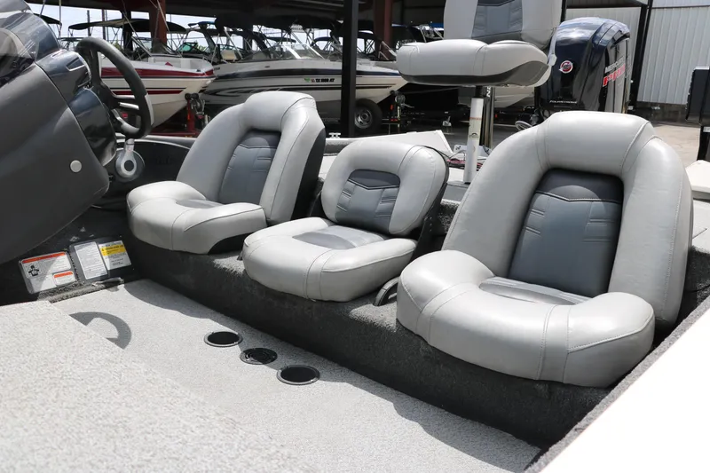 Slide: The Image of 2018 Tracker Pro Team 195 TXW boat interior with gray seating, steering wheel, and cup holders. - 24
