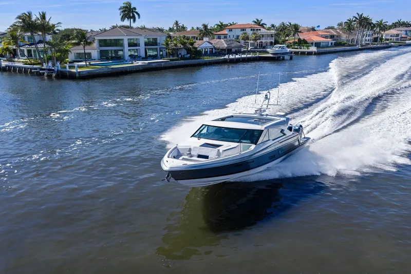 Slide: The Image of 2025 Formula 500 Super Sport Crossover cruising on a scenic waterfront with luxury homes. - 67