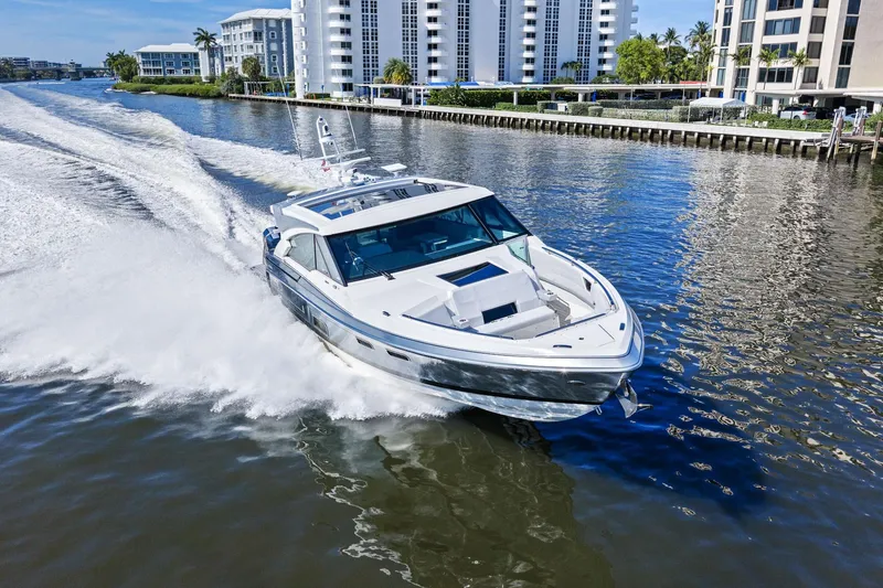 Slide: The Image of 2025 Formula 500 Super Sport Crossover cruising on a scenic waterway near modern buildings. - 69